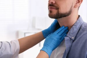 man getting his thyroid check by an emergency room nurse
