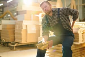 worker sitting down holding back in pain