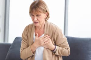 woman holding her chest in pain