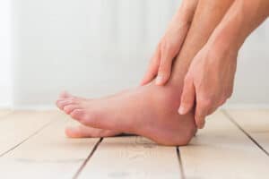 Person holding swollend ankle