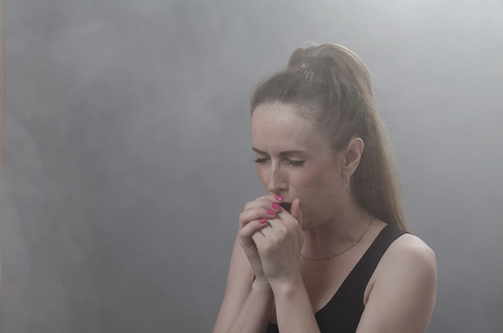 Woman coughing from smoke