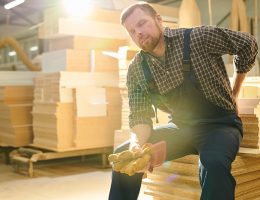 worker sitting down holding back in pain