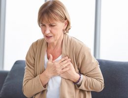 woman holding her chest in pain
